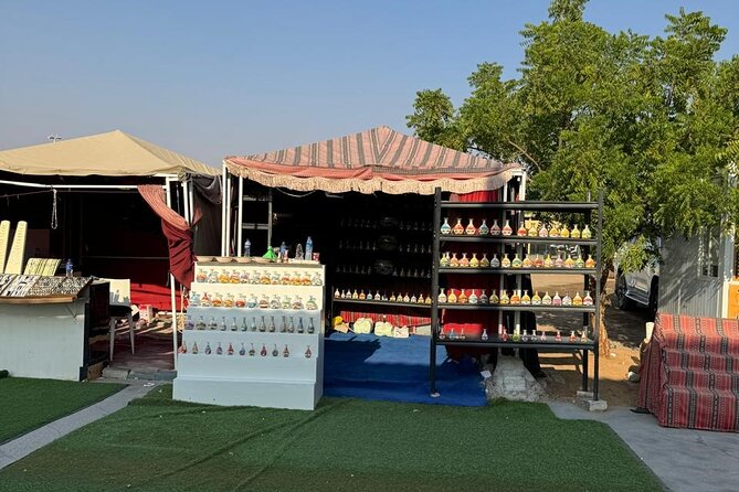 Dubai Desert Safari Dune Bashing, Camel Ride, Sandboarding & BBQ - Sunset at the Bedouin-inspired camp