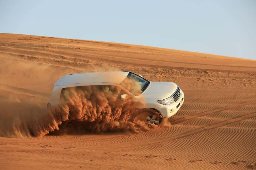 Dubai: Desert Safari, Quad Bike, Sandboarding, Camels & BBQ - Sandboarding on the steep red dunes
