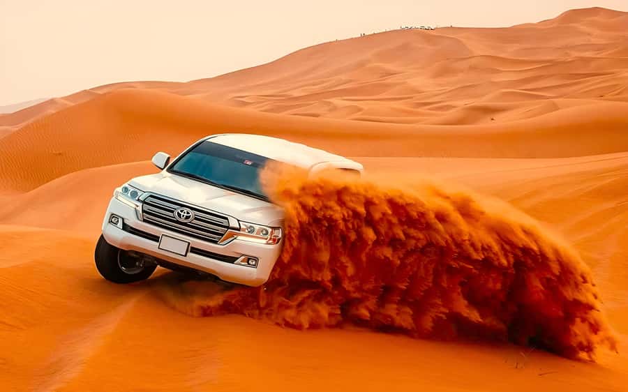 Dubai: Tour with BBQ Dinner, Camel Ride, & Traditional Show - Dune bashing, sandboarding, and the sunset stop