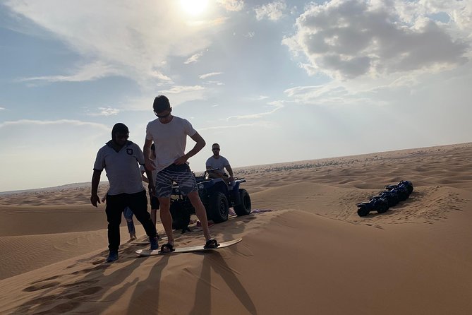 Dubai: Unique SUNSET Quad Bike Red Dunes Safari - Sandboarding with the evening sun behind you